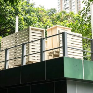 屋頂鋁合金安全圍欄，搭配橫條鋁百葉遮飾牆，戶外平台護欄，香港市政公廁屋頂設備防護欄，綠樹背景，市政工程鋁製圍欄實拍