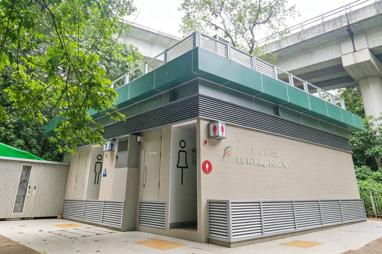 寮肚村公廁外牆鋁合金百葉及鋁窗，香港市政公廁建築外觀，深綠色鋁板頂部結構，橫向鋁通風百葉，淺色牆磚搭配鋁合金門窗，印有「寮肚村公廁 Liu To Village Public Toilet」中英標示，戶外市政建築實拍