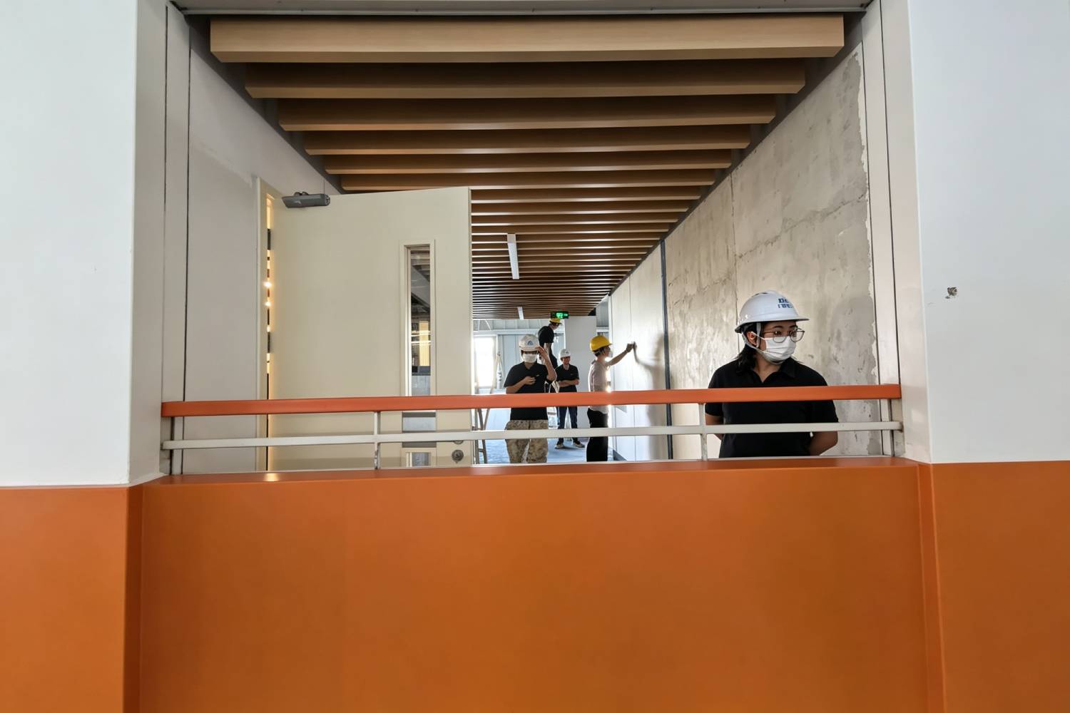 模塊化辦公室走廊｜木色條狀天花連橙色護欄施工實景