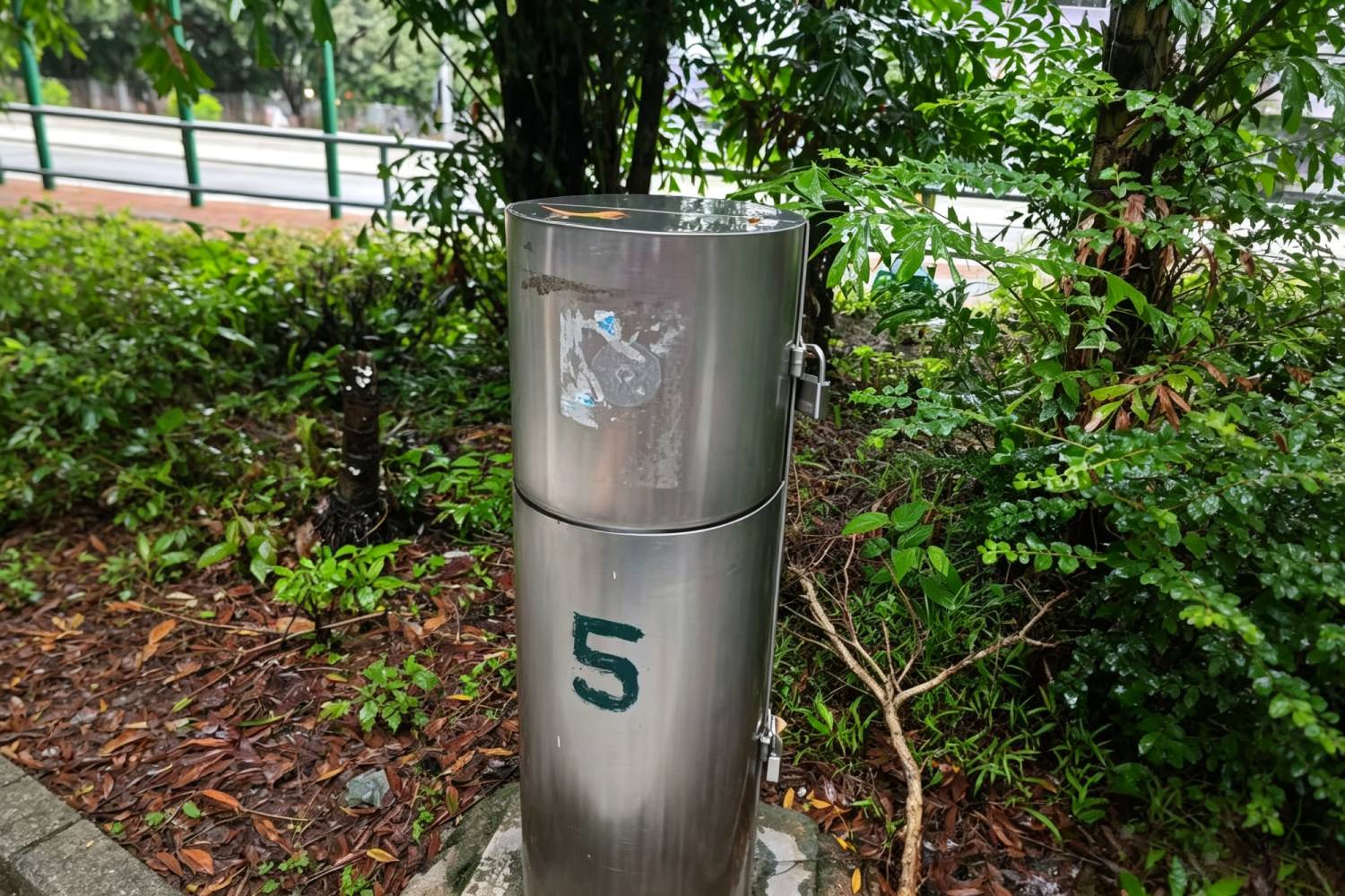 戶外圓筒型不鏽鋼灌溉水龍頭櫃，不鏽鋼柱體水掣箱，帶掛鎖防盜設計，外牆標註編號 5，公園園藝灌溉設備保護櫃，香港市政園林工程不鏽鋼設備實拍